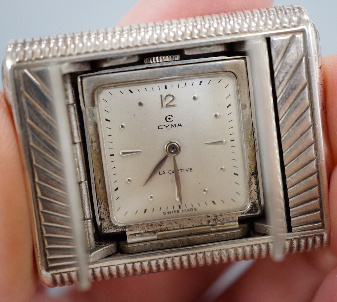 A mid 20th century 925 Cyma La Captive travelling watch, with 'rising sun' decoration, 47mm, in Bornand & Cie fitted leather case.